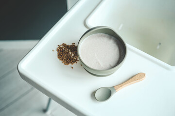 Buckwheat porridge for children in a plate. Feeding children healthy porridge