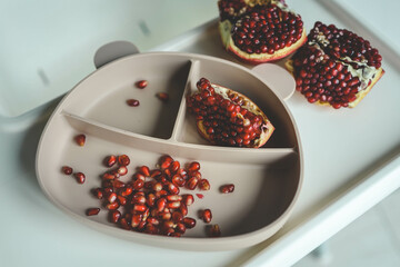 Baby eats pomegranate, first complementary feeding concept