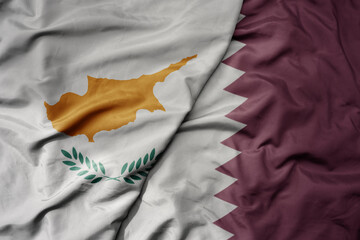big waving national colorful flag of qatar and national flag of cyprus.