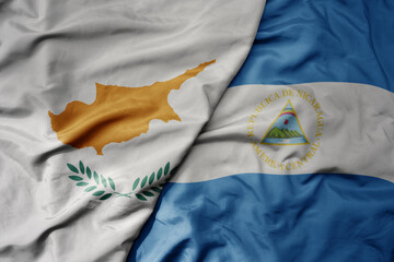 big waving national colorful flag of nicaragua and national flag of cyprus.