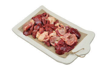 Raw chicken giblets on a ceramic board. Isolated on white background. Chicken stomachs, hearts and livers are prepared for cooking.