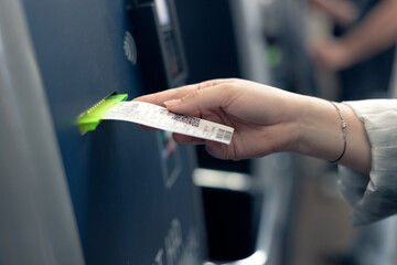 A young woman buys a ticket for public transport from a machine, automatic ticket terminal