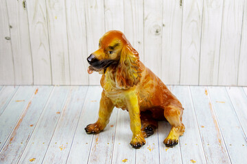 A brown ceramic dog on a gray wooden table. Design, painting, applied art, ceramics.
