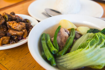Nilagang Baka or Filipino boiled beef soup with vegetables, and Tokwa and Baboy dish served with rice and soy sauce condiments.