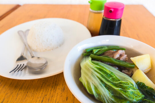 Nilagang Baka or Filipino boiled beef soup with vegetables served with rice and soy sauce condiments.