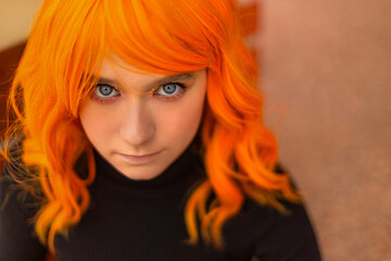 Close-up portrait of girl teenager with creative colored orange hair and hairstyle. Lifestyle photo. Cosplay on an anime character. - 738046702