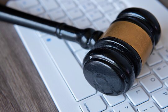 Judge gavel on top of white keyboard. Cybercrime, legal, law and online auction concept.