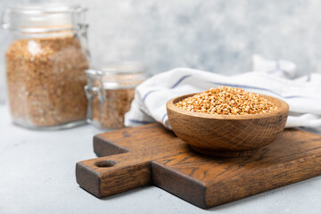 Green buckwheat in a bowl on a wooden kitchen table.Superfood.Raw buckwheat porridge.Healthy vegan food concept, eco products, diet. Copy space.Organic food.weight loss and proper nutrition.