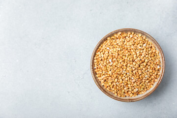 Green buckwheat in a bowl on a wooden kitchen table.Superfood.Raw buckwheat porridge.Healthy vegan food concept, eco products, diet. Copy space.Organic food.weight loss and proper nutrition.