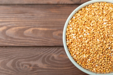 Green buckwheat in a bowl on a wooden kitchen table.Superfood.Raw buckwheat porridge.Healthy vegan food concept, eco products, diet. Copy space.Organic food.weight loss and proper nutrition.