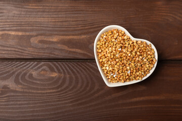 Green buckwheat in a bowl on a wooden kitchen table.Superfood.Raw buckwheat porridge.Healthy vegan food concept, eco products, diet. Copy space.Organic food.weight loss and proper nutrition.