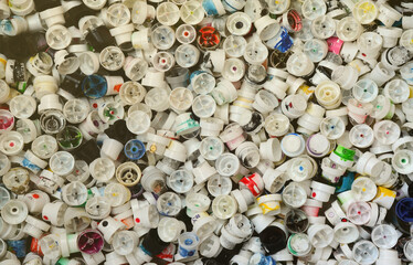 A large number of caps from cans of aerosol paint for graffiti. Smeared with colored paint nozzles...