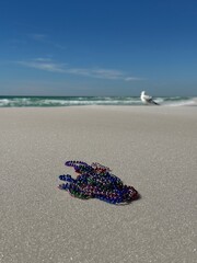 Mardi Gras concept with beads and blur beach background 