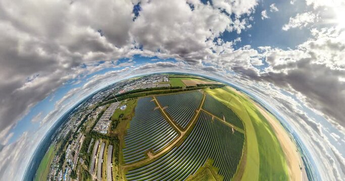 abstract circular curvature of surface of earth and twisting of sky over on farm field of solar panels