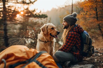 A serene moment as a woman and her dog enjoy the tranquility of an autumnal forest