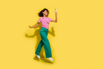 Fototapeta na wymiar Full body profile photo of crazy sporty lady jump use smart phone empty space isolated on yellow color background