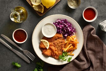 Schnitzel with potato fries, cabbage salad and sauce