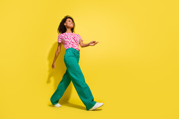 Fototapeta na wymiar Full body profile photo of cheerful nice lady look walking empty space ad isolated on yellow color background