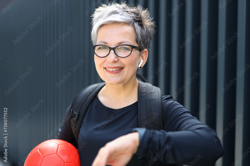 Sticker a mature caucasian woman enjoys a sunny summer day, smiling while playing sports outdoors.