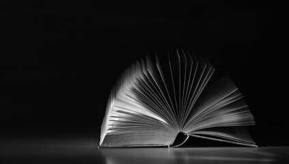 Open book close up, black and white, reading, education, knowledge concept.Black background,free...