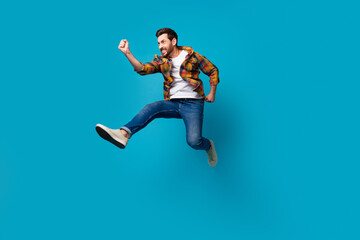 Fototapeta na wymiar Full size photo of handsome young male running fast shopping promo dressed stylish checkered outfit isolated on blue color background