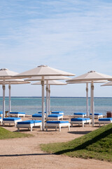 Fototapeta na wymiar Empty beach with umbrellas and sun loungers
