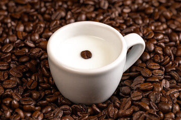 espresso cup with milk and coffee beans