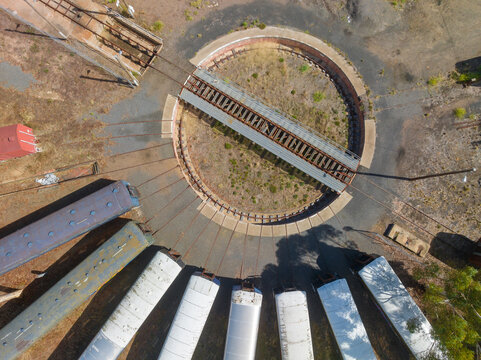 Aerial view of long train carriages lined up around a railway turntable