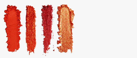 Set of strokes of eye shadow, glitter, blush in red shades on a light background