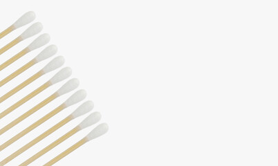 Many cotton swabs for ears are laid out in a row diagonally on a light background.