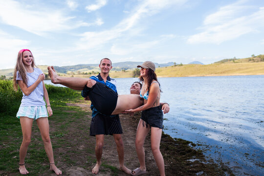 Group of Aussie teens being silly together by the water on summer afternoon