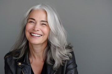 Fototapeta premium Smiling Senior Woman with Silver Hair in a Black Leather Jacket