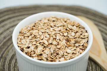 Close up of healthy food and organic oat flakes in white cup. Vegan food.