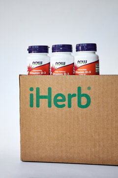 iHerb online store, Unpacking the parcel with vitamins and Nutritional Supplements. Three jars of vitamin D3, NOW Foods Company, sticking out of Brown Cardboard box. Bishkek, Kyrgyzstan - 8 Dec 2023. 