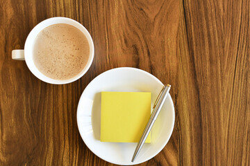 Café con leche y libreta de notas. Espacio para texto al lado derecho.