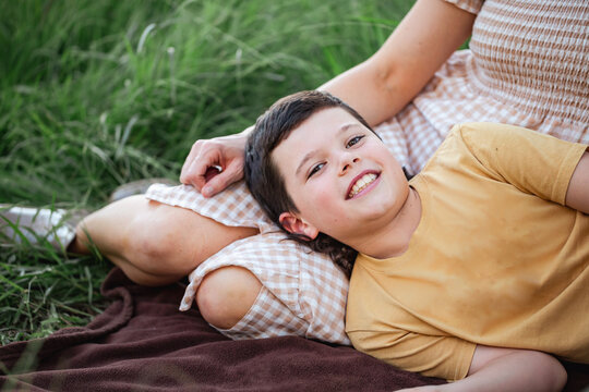 Portrait of boy lying on mother's lap in rural country bush setting