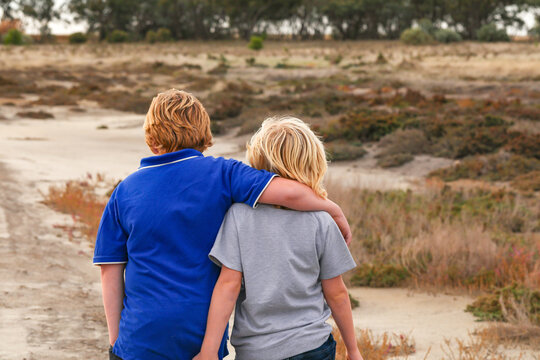 Brothers together exploring desolate dry lake. Family outing in the Australian bush.