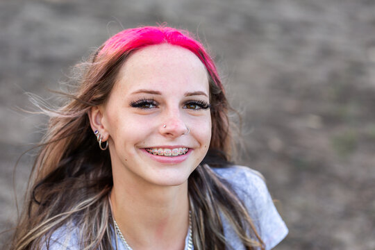 Portrait of happy teen girl with pink hair and braces