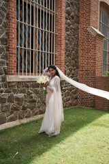 Obraz premium south Asian, wedding photography, woman, Christian wedding, outdoor, bouquet, holding a flower close to her