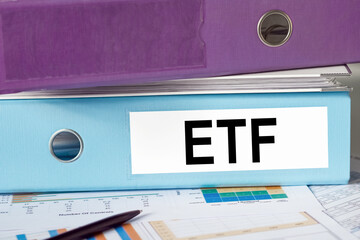 ETF - stock exchange text fund on folder, folders lie on a financial chart