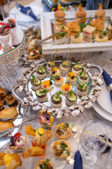 Elegant Catering Food Display with Variety of Appetizers and Desserts on White Tablecloths