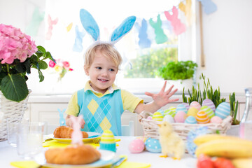 Kids at Easter breakfast. Eggs basket, bunny ears.