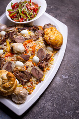 Traditional Uzbek Plov Dish with Mutton, Carrots, and Rice on White Plate.