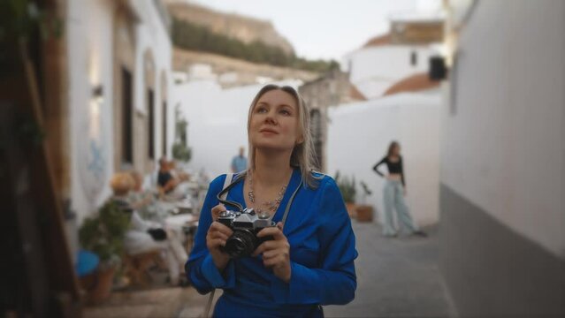 Woman tourist with vintage camera in the old town.