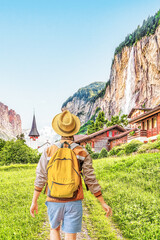 Traveling young man visiting Staubbach waterfall at Lauterbrunnen rural village Switzerland. 