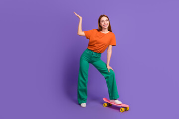 Full length photo of charming cheerful girl presenting empty space offer isolated on violet color background