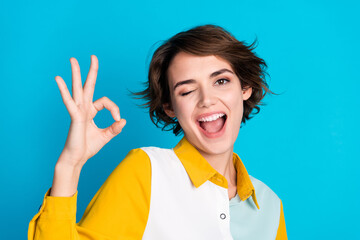 Photo of confident pretty woman wear shirt showing okey gesture winking isolated blue color...