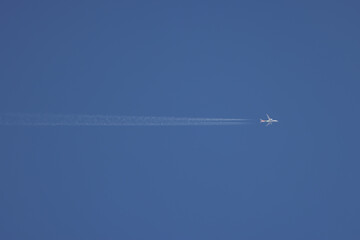 a high flying passenger plane with contrails