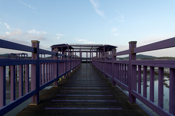 Fototapeta na wymiar purple wooden bridge at the seaside