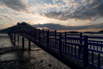 Obraz premium View of the bridge at the seaside during sunset